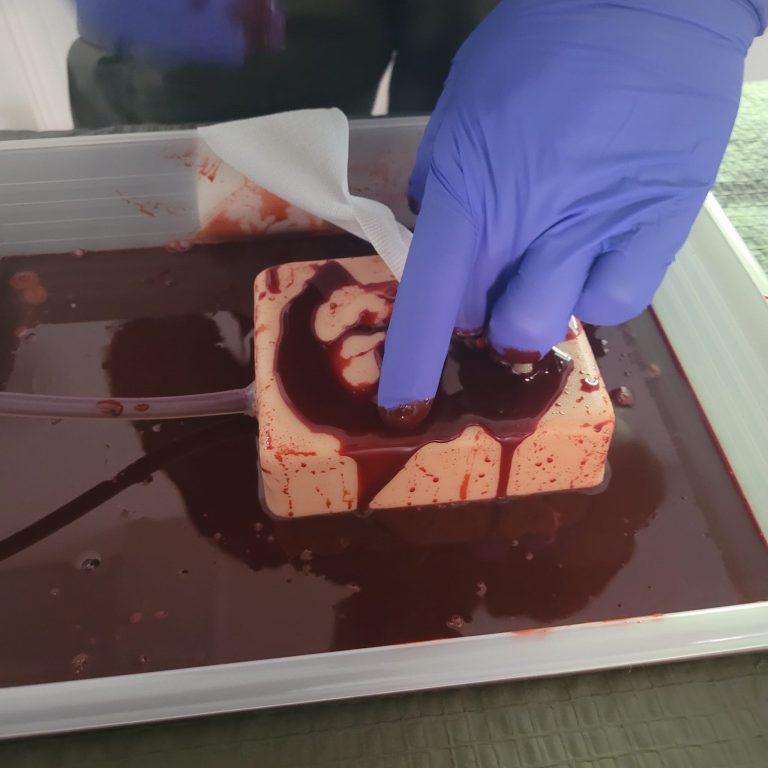Wound Packing: Eine Wunde am Übungsmodell wird mit Mullbinde austamponiert